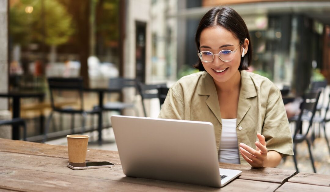 Young professional on a video call from an outdoor café, discussing VPN alternatives for business and secure remote access.